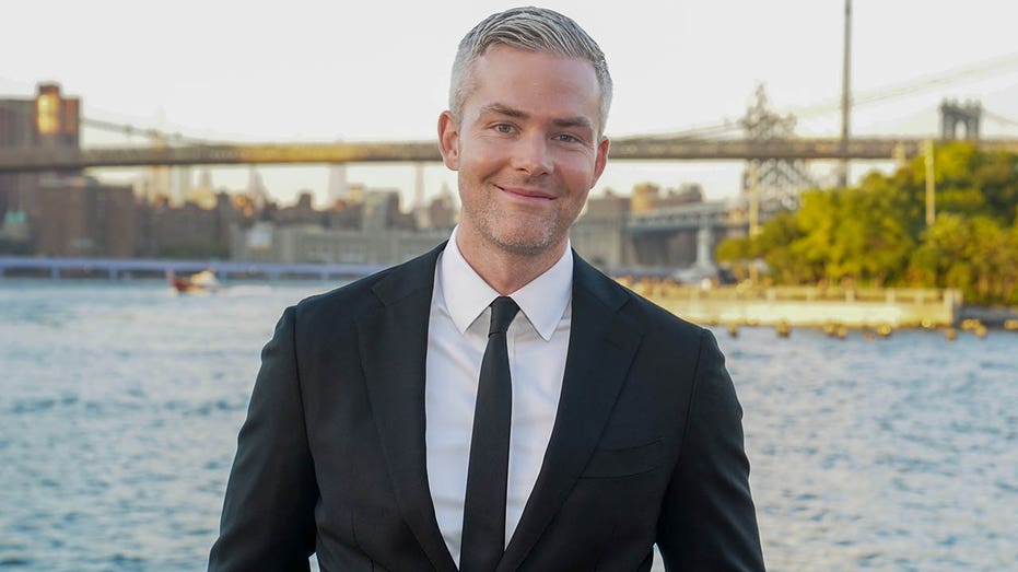 ryan serhant smiling in front of bridge