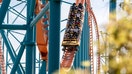 Visitors ride the roller coaster Scream at the theme park Six Flags Magic Mountain in April 2021, in Valencia, Calif.