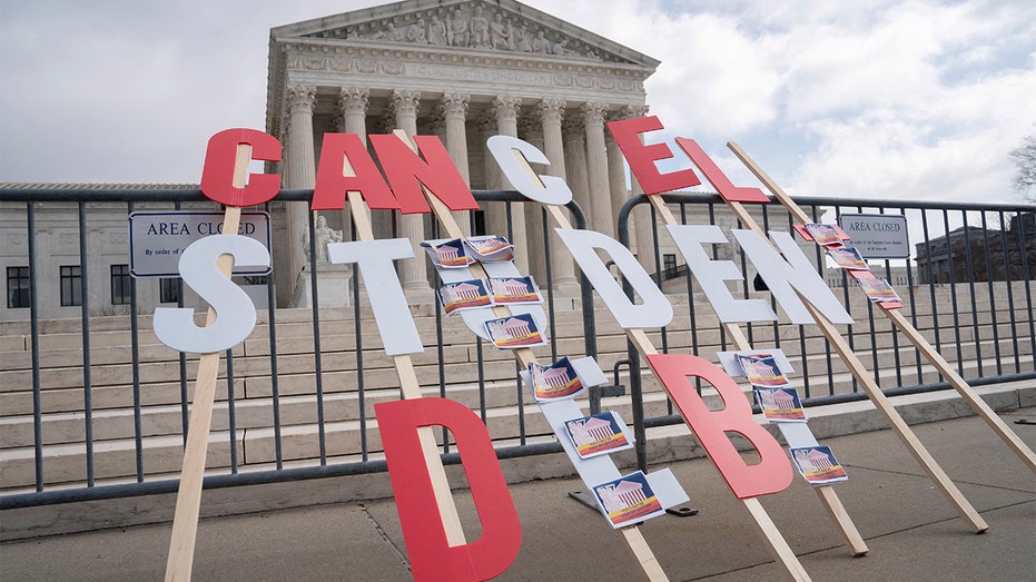 A sign urges President Biden to cancel federal student loan debt