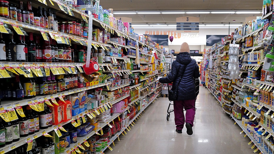 person grocery shopping down an aisle